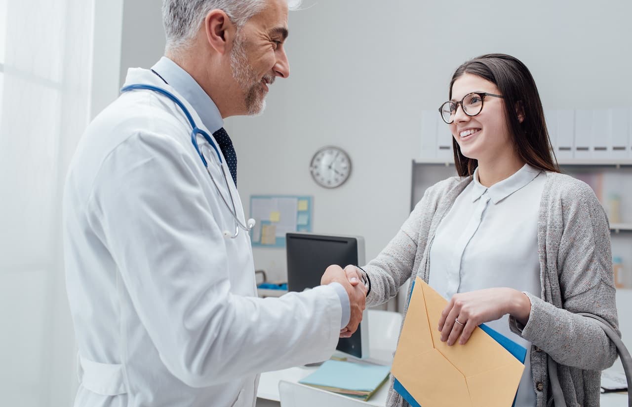 Un médecin accueille chaleureusement une patiente en consultation